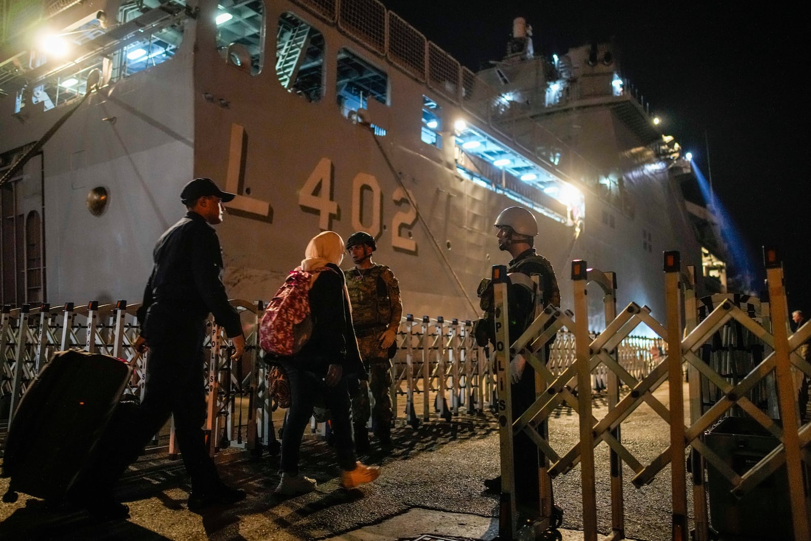 Turkish citizens walk to board Turkish military ships to evacuate them from Lebanon to Turkey, in Beirut port on Wednesday, Oct. 9, 2024. (AP Photo/Emrah Gurel)