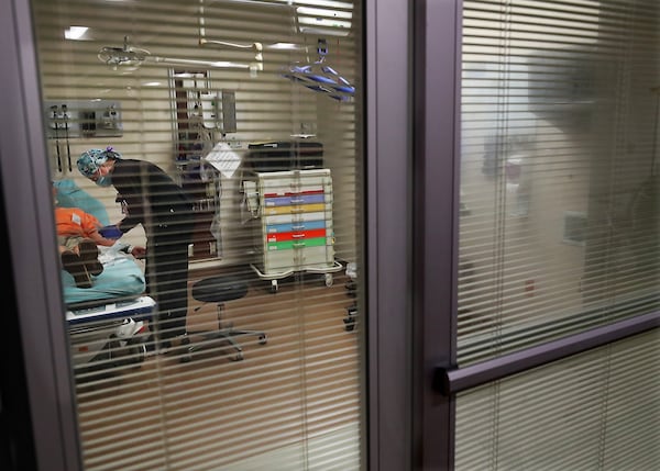 Carey Mullis, a registered nurse, works with a COVID-19 patient just after he was brought to the Colquitt Regional Medical Center by ambulance on Thursday.  Curtis Compton / Curtis.Compton@ajc.com