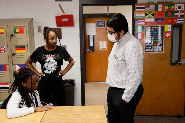 Daniel Garcia, a social studies teacher at Shiloh Middle School in Gwinnett County, chats with a student as she and a classmate wait for dismissal. Despite facing several challenges during the academic year, Garcia remains steadfast in inspiring and motivating his students to reach their full potential. Miguel Martinez /miguel.martinezjimenez@ajc.com