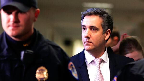 Michael Cohen, President Donald Trump's former lawyer, right, leaves after a closed door Senate Intelligence Committee hearing on Capitol Hill in Washington, Tuesday, Feb. 26, 2019.