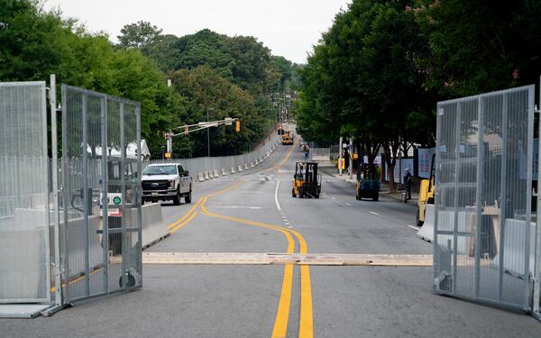 Workers install temporary fencing on 10th Street in Atlanta on Thursday, June 27, 2024. (Ben Hendren for the Atlanta Journal-Constitution)