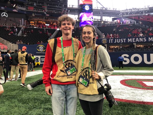 Chamberlain Smith (R) poses with fellow UGA photography intern Tony Walsh on the field before Saturday's game. (Chip Towers/ctowers@ajc.com)