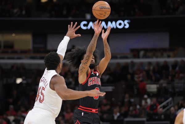 Chicago Bulls guard Coby White shoots a 3-point basket against Cleveland Cavaliers guard Donovan Mitchell during an NBA basketball game, Monday, Nov. 11, 2024, in Chicago. (AP Photo/Melissa Tamez)