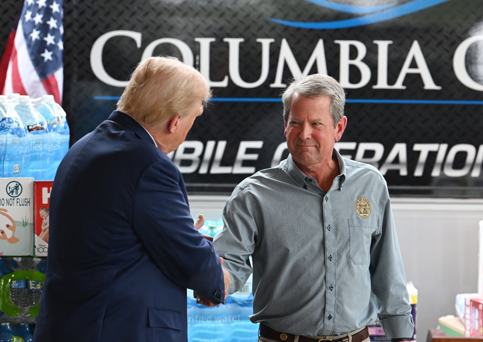 Former President Donald Trump greets with Gov. Brian Kemp during a press event while traveling to east Georgia to survey damage from Hurricane Helene, Friday, October 4, 2024, in Evans. Former President Donald Trump and Gov. Brian Kemp made their first appearance together since before the 2020 election, traveling to east Georgia to survey damage from Hurricane Helene. (Hyosub Shin / AJC)