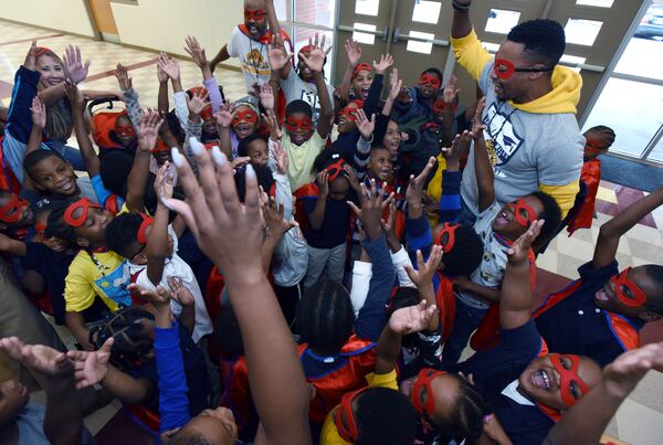  Assistant principal Robert Stewart (right) cheers students after they participated in the attendance run at Miles Elementary School on Friday, November 22, 2019. (Hyosub Shin / Hyosub.Shin@ajc.com)