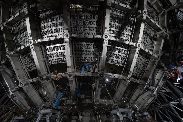 Workers labor on the underside of the cosmic detector located 2297 feet (700 meters) underground at the Jiangmen Underground Neutrino Observatory in Kaiping, southern China's Guangdong province on Friday, Oct. 11, 2024. (AP Photo/Ng Han Guan)