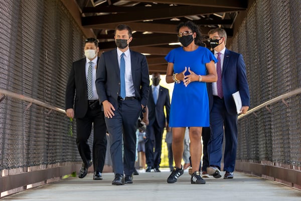 U.S. Secretary of Transportation Pete Buttigieg, second from left, gets a look at the railroad tracks that run through East Point during a tour by the city's mayor, Deana Holiday Ingraham, during a visit in May. (Alyssa Pointer / Alyssa.Pointer@ajc.com)