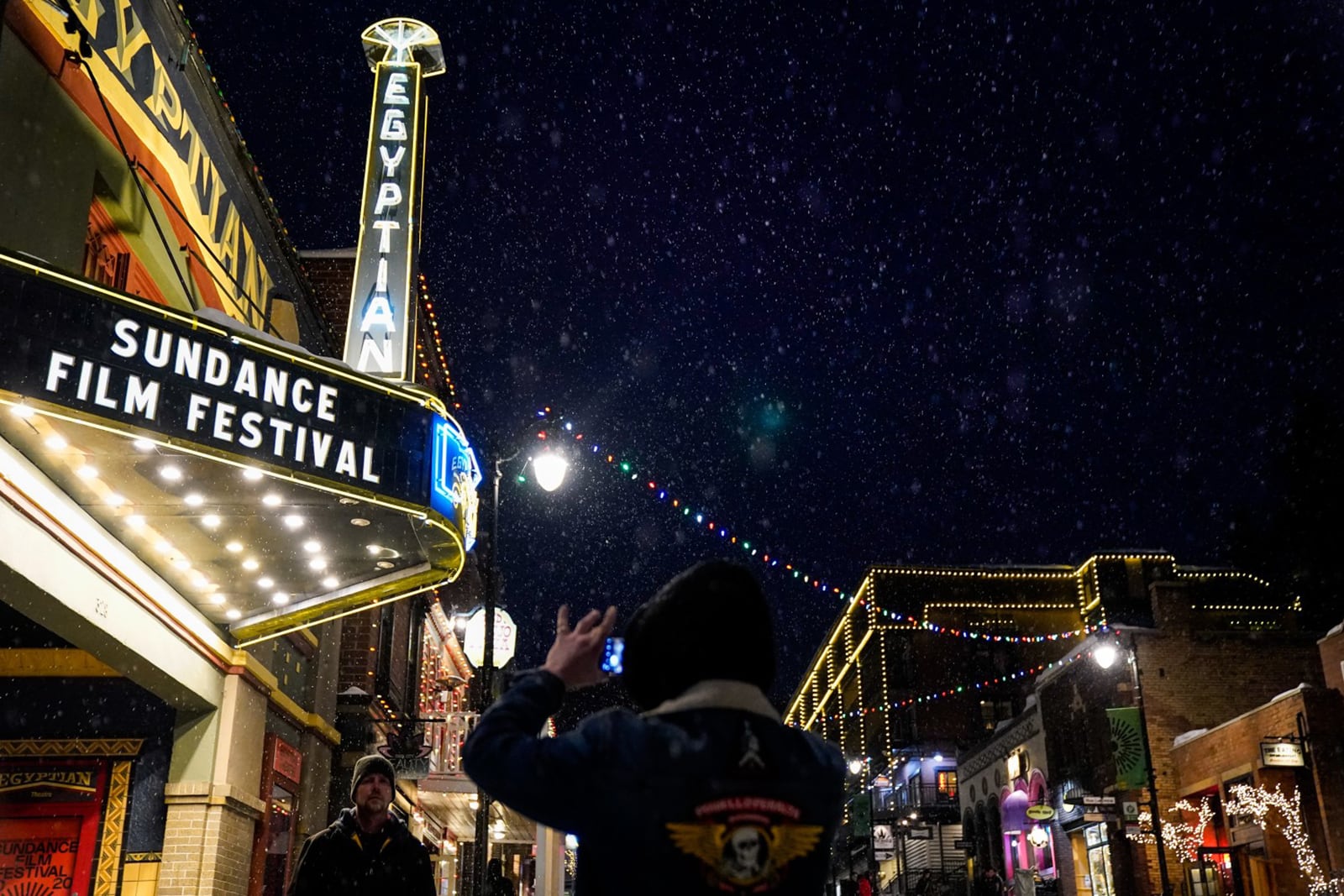 People take photos beneath the marquee of the Egyptian Theater during the Sundance Film Festival on Jan. 22, 2020, in Park City, Utah.