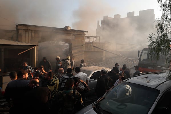 Security officers and rescuers gather at a destroyed building hit in an Israeli airstrike in Damascus, Syria, Thursday, Nov. 14, 2024. (AP Photo/Omar Sanadiki)