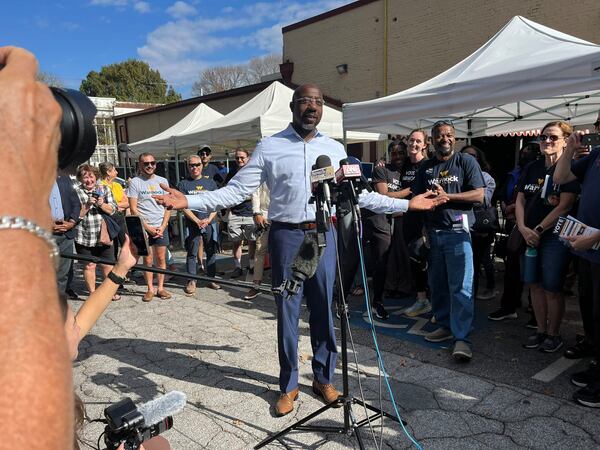 Sen. Raphael Warnock speaks with campaign volunteers before they go out for some Election Day canvassing.