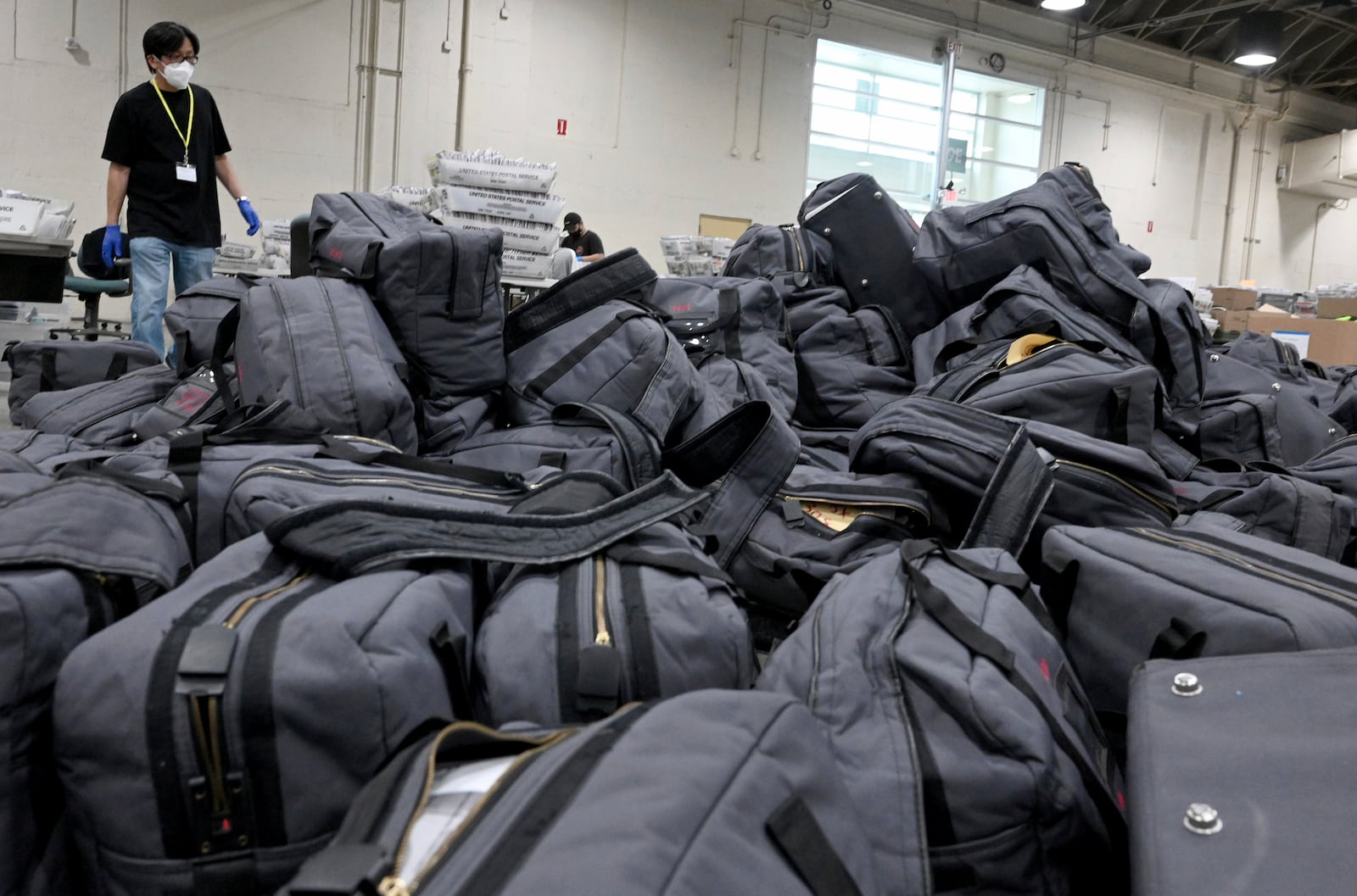 FILE - A worker prepares to take bags of ballots to be sorted and processed by the Los Angeles County Registrar at the temporary building at the Pomona Fairplex in Pomona, Calif., Thursday, Nov. 5, 2020. (Keith Birmingham/The Orange County Register via AP)