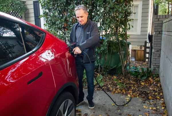 Marshall Norseng disconnects his Tesla from the charger before his commute to Duluth at his Atlanta home Tuesday, November 7, 2021.  STEVE SCHAEFER FOR THE ATLANTA JOURNAL-CONSTITUTION