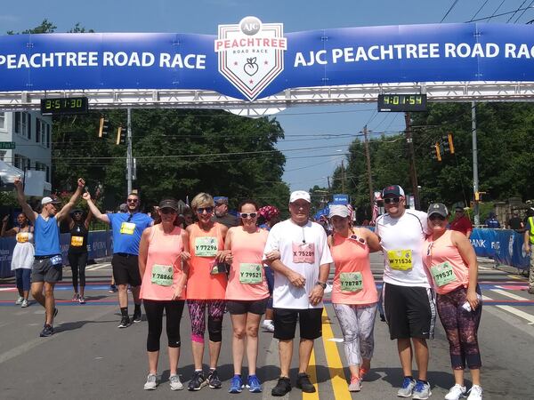 It was a family affair for Gwinnett dad Rick Shimandle’s first AJC Peachtree Road Race: Daughter Charleaze Langley (from left), wife Adie Shimandle, daughter Alexandria Wilhite, Rick Shimandle, daughter Kennsington Jones, son-in-law Donovan Wilhite IV, and daughter Teanna Wilson are shown at the finish line. The daughters came from near and far (Sugar Hill, Flowery Branch, Jacksonville, Fla., and Las Vegas) to support their dad. CONTRIBUTED