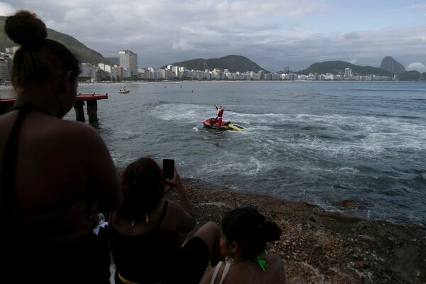 A firefighter dressed as Santa Claus waves from a jet ski off of Copacabana Beach in Rio de Janeiro, Tuesday, Dec. 17, 2024. (AP Photo/Bruna Prado)