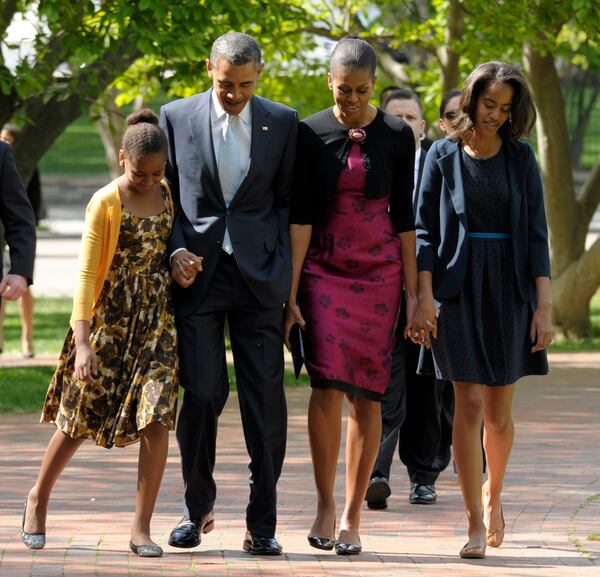 FILE - In this April 8, 2012, file photo, President Barack Obama, first lady Michelle Obama, daughters Malia, right, and Sasha walk across the square from the White House to St. John's Episcopal Church for Easter service in Washington. Michelle Obama has a new look, both in person and online, and with the president's re-election, she has four more years as first lady, too. The first lady is trying to figure out what comes next for this self-described "mom in chief" who also is a champion of healthier eating, an advocate for military families, a fitness buff and the best-selling author of a book about her White House garden. For certain, she'll press ahead with her well-publicized efforts to reduce childhood obesity and rally the country around its service members. (AP Photo/Susan Walsh, File) In this 2012 photo, President Barack Obama, first lady Michelle Obama, daughters Malia, right, and Sasha walk across the square from the White House to St. John's Episcopal Church for Easter service in Washington. (AP Photo)