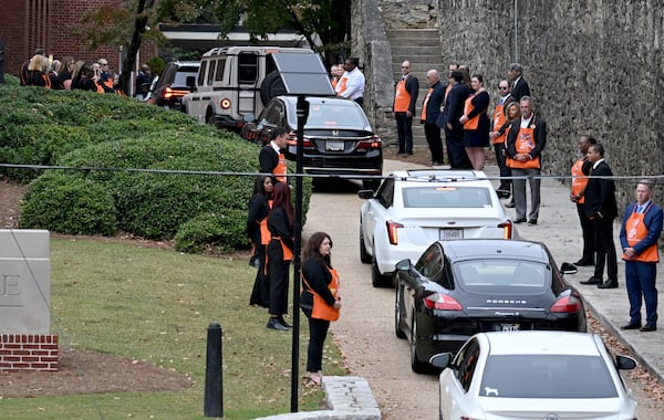 People wearing Home Depot aprons greet guests arriving for funeral services of Bernie Marcus at the Temple in Atlanta last Thursday.