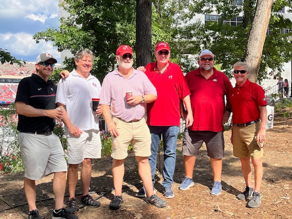 David Lilliston and Rick Clardy (middle) are founding members and co-captains of the "Take No Prisoners" tailgating group that has occupied a space on Field Street for the past 20 years. Here they pose next to Sanford Stadium on Oct. 5, 2024, with other "TNP" regulars, including (L-R) Mike Kozer, Pete Reuning, Lilliston, Clardy, Jeff Klag and Kim Chapman. (Photo by Chip Towers/ctowers@ajc.com)