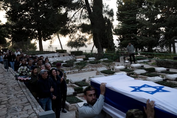 The family of Israeli Defense Forces Sgt. First Class (res.) Roi Sasson, who was killed in action in the Gaza Strip, walk behind his coffin during his funeral at Mt. Herzl military cemetery in Jerusalem, Wednesday, Nov. 20, 2024. (AP Photo/Maya Alleruzzo)