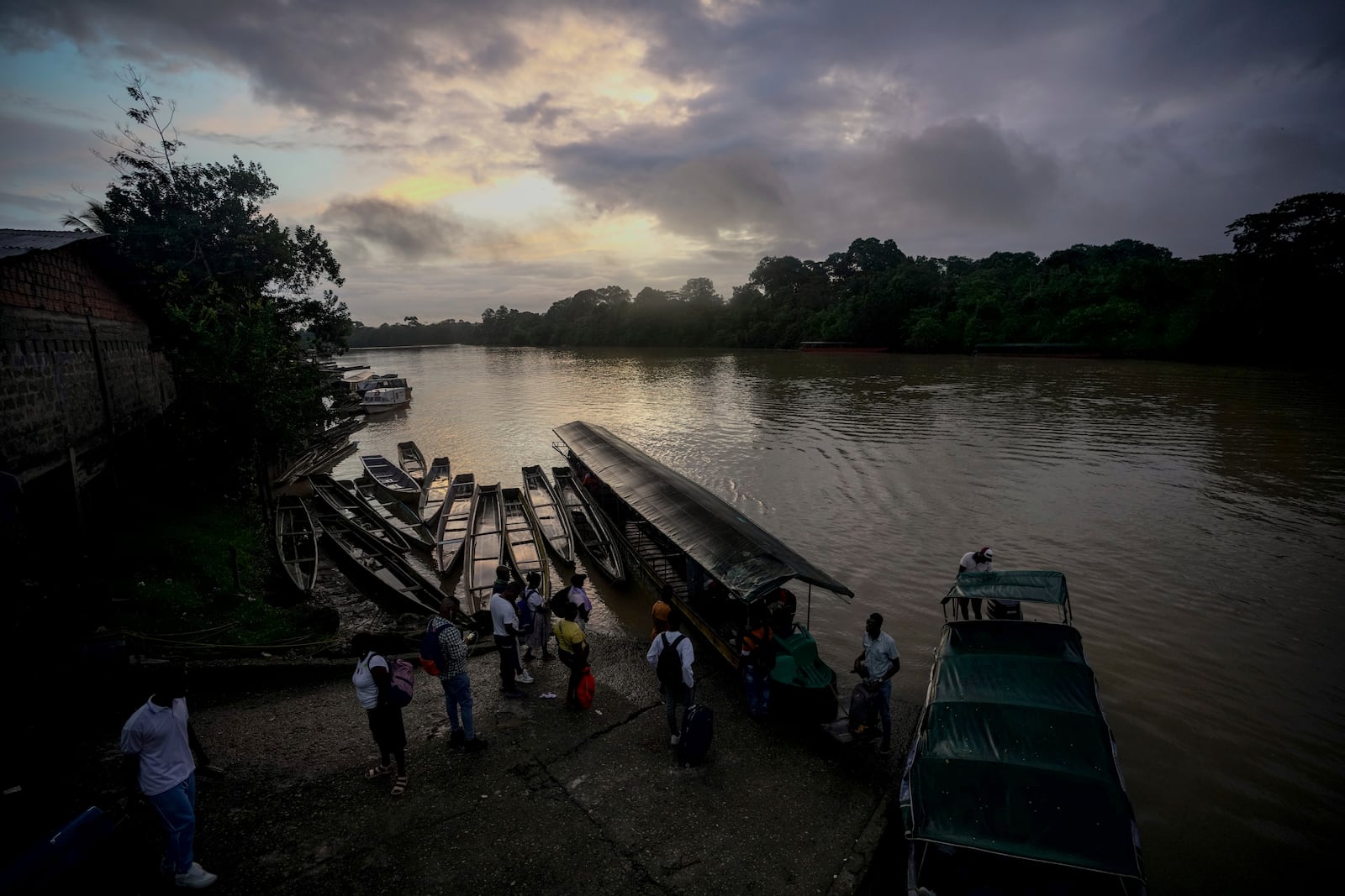 People take boats early in the morning to go to work in mining in Paimado, Colombia, Monday, Sept. 23, 2024. (AP Photo/Ivan Valencia)