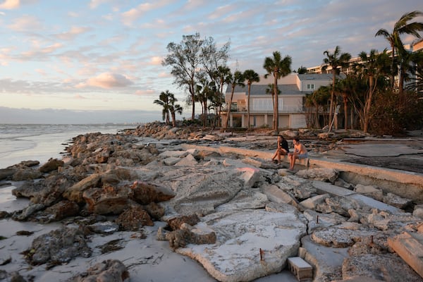 FILE - Young people from Sarasota, Fla., visit a beach on Siesta Key, Fla., on Oct. 10, 2024. The beach was damaged by Hurricane Helene and Hurricane Milton. (AP Photo/Rebecca Blackwell, File)