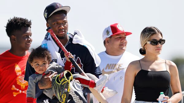  031722 North Port: Atlanta Braves outfielder Ronald Acuna carries his son Ronald Acuna Jr. II after he finishes up practice for the day and leaves with his partner Maria Laborde (right) during Spring Training on Thursday, March 17, 2022, in North Port.    “Curtis Compton / Curtis.Compton@ajc.com”