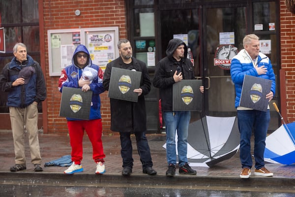 Mourners watch as a funeral procession for fallen police officer Jeremy Labonte drives through downtown Roswell on Wednesday, February 12, 2025. The 24-year-old Roswell Police Department officer was shot to death on Friday evening. (Arvin Temkar / AJC)