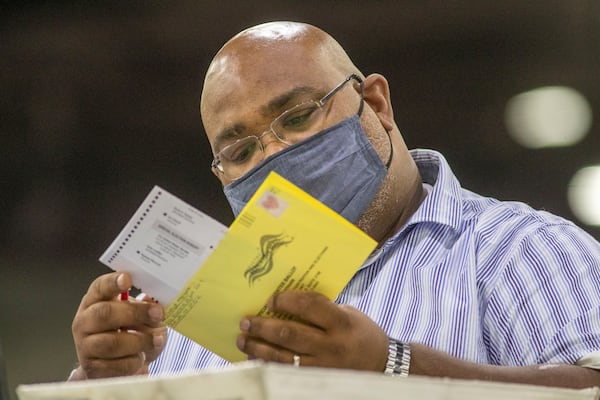 01/05/2021 — Atlanta, Georgia — A Fulton County elections worker prepares to count absentee ballots for Georgia’s Senate runoff elections at the Georgia World Congress Center in Atlanta, Tuesday, January 5, 2021. (Alyssa Pointer / Alyssa.Pointer@ajc.com)