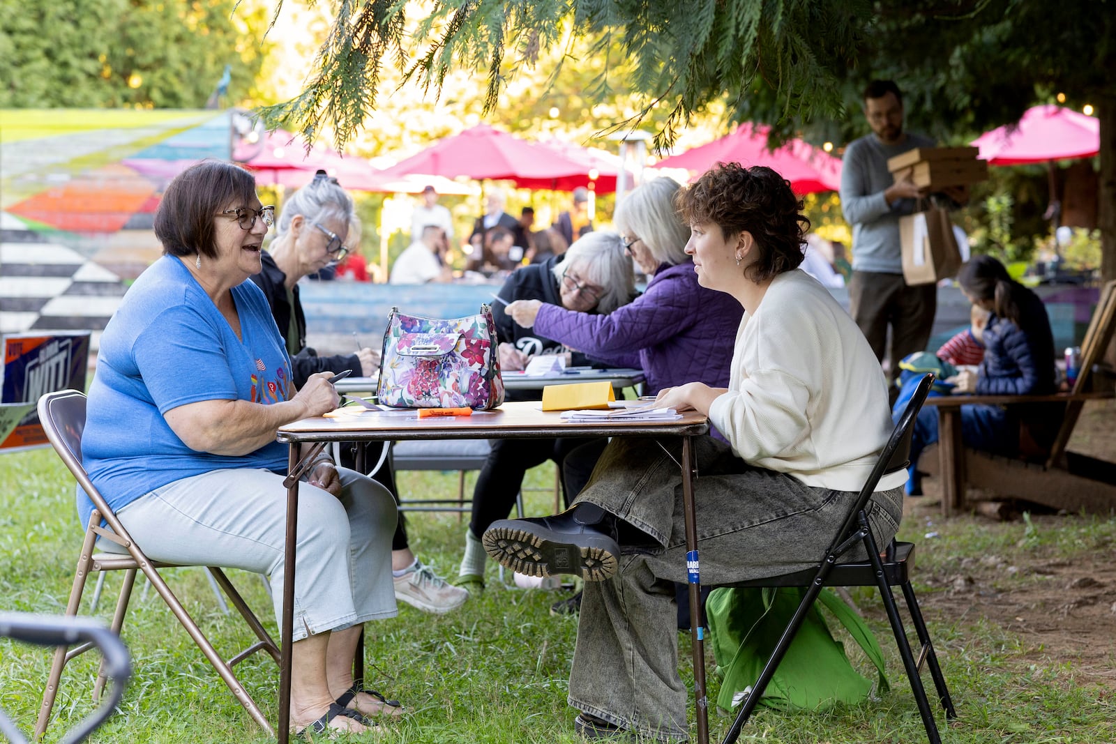 Nancy Gulotta and Cannon Slayton write postcards at IX Art Park in Charlottesville, Va., Thursday, Oct. 10, 2024. Charlottesville Democrats meet weekly to make phone calls, write postcards and send texts to get out the vote. (AP Photo/Ryan M. Kelly)