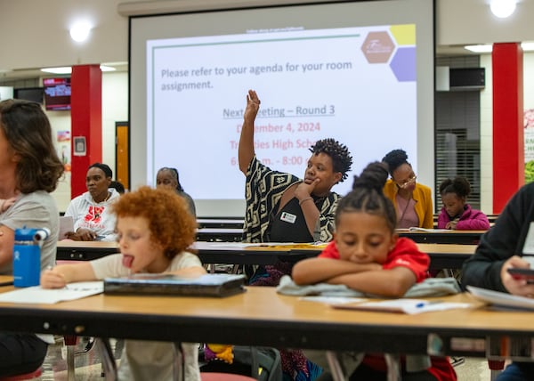 Concerned South Fulton Elementary school parents, including Shaunda Freeman, center, ask questions of Fulton County Schools administrators at Tri-Cities High School on Wednesday.  Jenni Girtman for the AJC