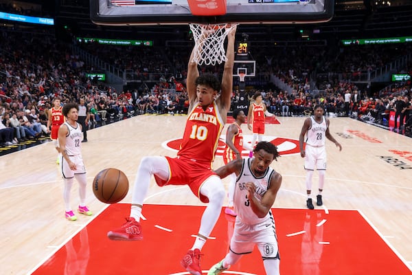 Atlanta Hawks forward Zaccharie Risacher (10) dunks against Brooklyn Nets center Nic Claxton (33) during the second half at State Farm Arena, Wednesday, October 23, 2024, in Atlanta. The Hawks won 120-116. (Jason Getz / AJC)

