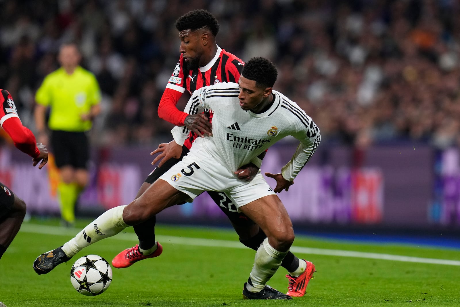 Real Madrid's Jude Bellingham, front, and AC Milan's Emerson Royal battle for the ball during the Champions League opening phase soccer match at the Santiago Bernabeu stadium in Madrid, Spain, Tuesday, Nov. 5, 2024. (AP Photo/Manu Fernandez)