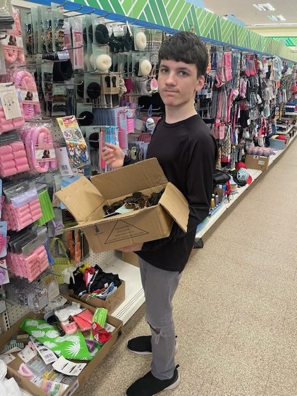 Luceas Forester stocks shelves in a discount store near his Cumming home. The 18-year-old, who has Phelan-McDermid syndrome, is able to get the care he needs thanks to assistance from Atlanta Legal Aid. Courtesy of Laraleigh Windom