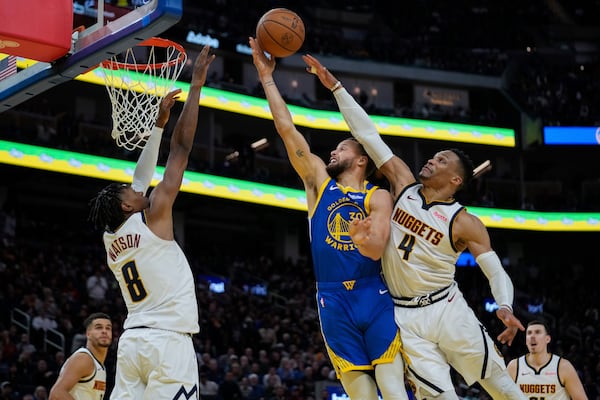 Golden State Warriors guard Stephen Curry (30) is fouled by Denver Nuggets guard Russell Westbrook (4) during the second half of an NBA basketball game Monday, March 17, 2025, in San Francisco. (AP Photo/Godofredo A. Vásquez)