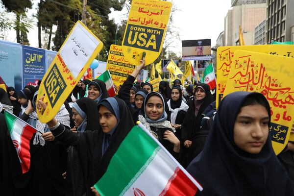 Iranian demonstrators chant slogans as they set fire to a representation of a makeshift U.S. flag during an annual rally in front of the former U.S. Embassy in Tehran, Iran, on Monday.