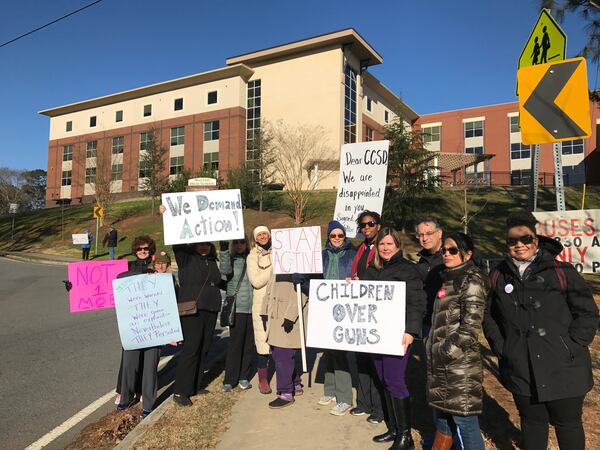 Parents and community members rally outside Walton High School in Cobb County on the morning of the walkout. VANESSA MCCRAY / AJC