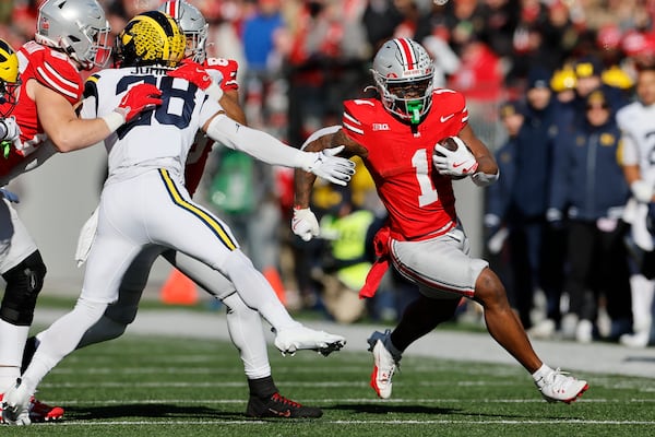 Ohio State running back Quinshon Judkins, right, cuts up field past Michigan defensive back Quinten Johnson during the first half of an NCAA college football game Saturday, Nov. 30, 2024, in Columbus, Ohio. (AP Photo/Jay LaPrete)