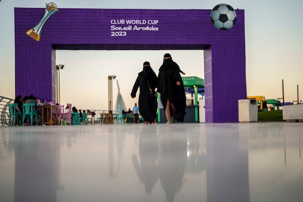 FILE - Women walk in front of a fan zone during the Soccer Club World Cup at the Jeddah Corniche in Jeddah, Saudi Arabia, Wednesday, Dec 13, 2023. (AP Photo/Manu Fernandez, File)