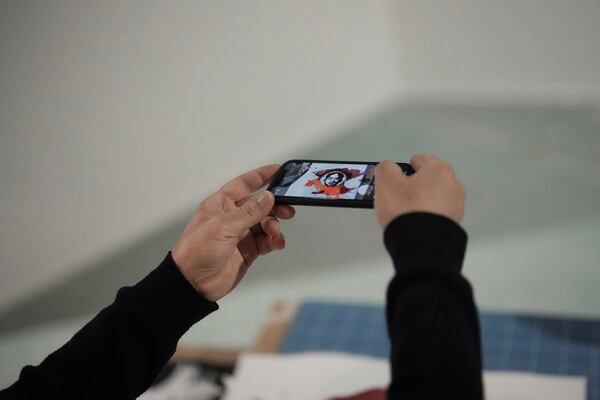 French street artist Shuck One takes a snapshot of his drawing representing Aimee Cesaire during the preparation of the exhibition "Paris Noir", at the Centre Pompidou Museum, in Paris, Tuesday, Feb. 18, 2025. (AP Photo/Thibault Camus)