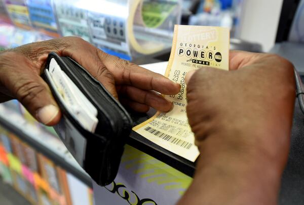 Bowler Samuels holds his Powerball ticket for a recent  drawing at Bodie's convenience store on 13th Street in Augusta, Ga., Friday afternoon Aug. 18, 2017. (Michael Holahan/The Augusta Chronicle via AP)