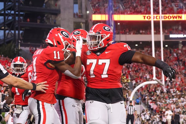 Georgia wide receiver Arian Smith (left) celebrates his 12-yard touchdown reception with Georgia offensive lineman Earnest Greene III (right) on Sept. 23, 2023, against UAB in Athens, Jason Getz/AJC 2023