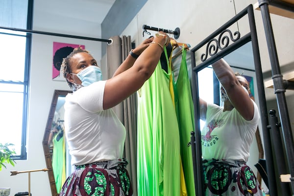 Frugal Chics Roc founder and creator Nyota Byfield adjusts a mannequin in her space in the Nia Building at Pittsburgh Yards. (Rebecca Wright for the Atlanta Journal-Constitution)