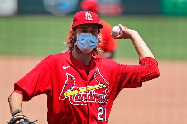 St. Louis Cardinals pitcher Andrew Miller wears a protective face mask as he tosses a ball during baseball practice at Busch Stadium Friday, July 3, 2020, in St. Louis. (AP Photo/Jeff Roberson)