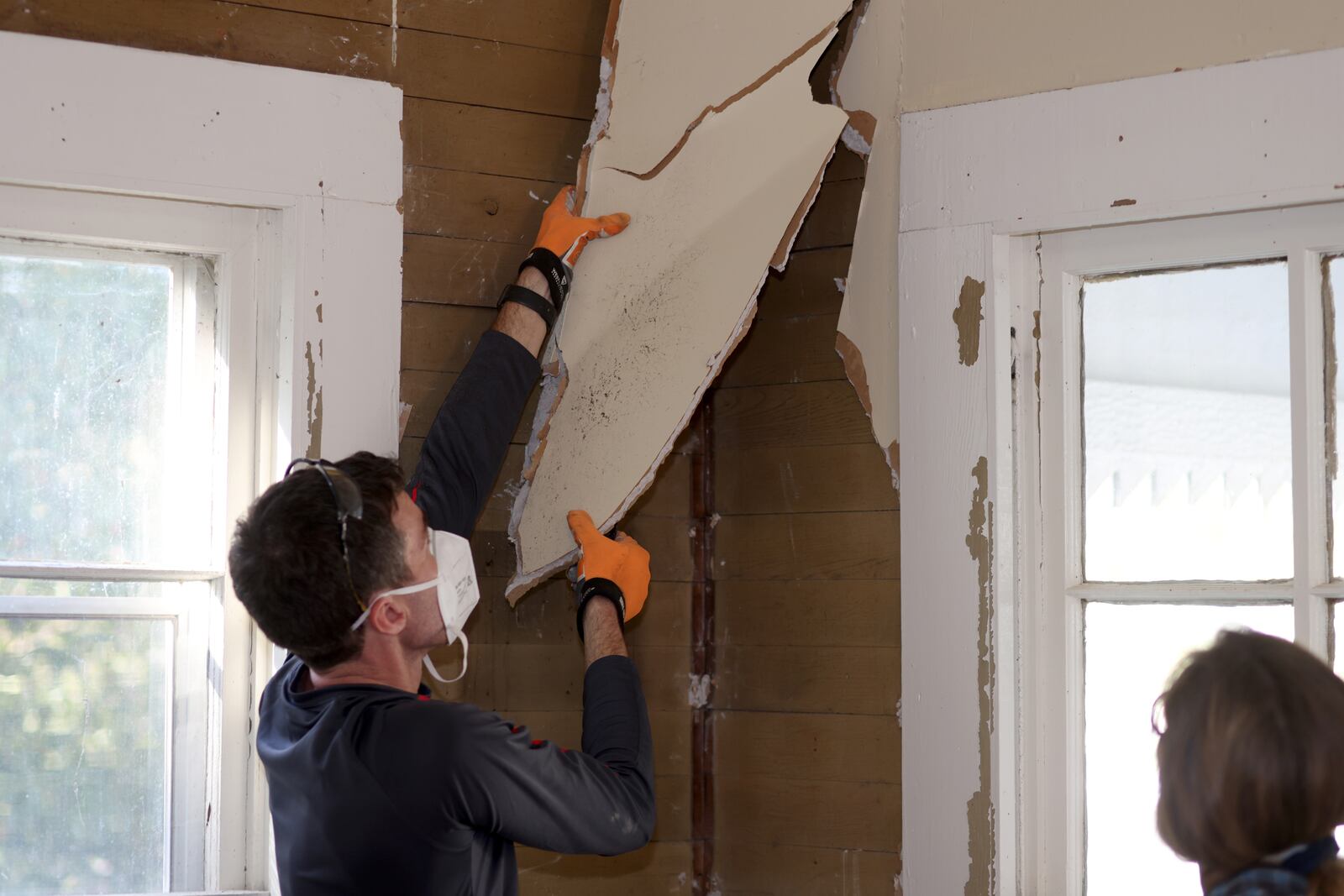 Jared Kirschner removes the drywall from the walls as he and his wife Brandy are in the beginning phases of renovating the Hembree farmhouse. (Jason Getz / Jason.Getz@ajc.com)