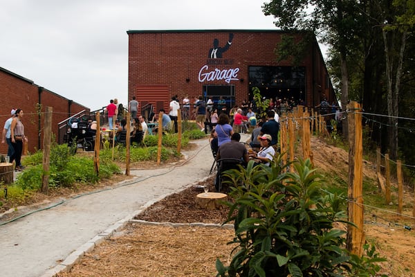 The path into the Monday Night Garage is lined with seating and fire pits, and there’s a dedicated space for cornhole. CONTRIBUTED BY HENRI HOLLIS