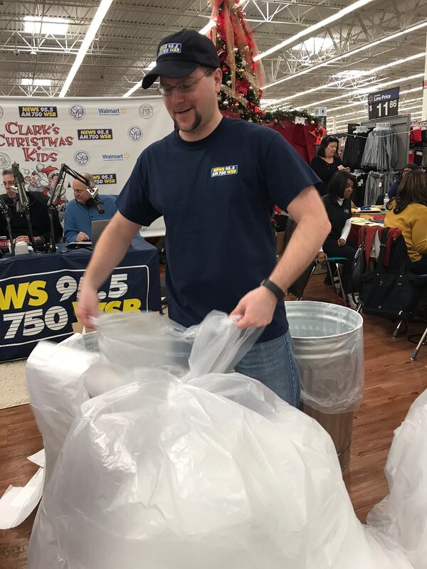  Justin Tysinger helps ready bags for toys and other gifts. CREDIT: Rodney Ho/rho@ajc.com