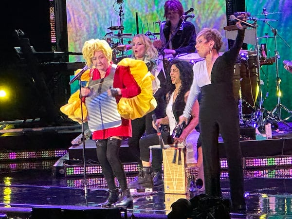 Cyndi Lauper wore a washboard, a yellow wig and bright yellow frilly accents over a red dress during her cover of Wanda Jackson's "Funnel of Love" from her 2016 album "Detour." RODNEY HO/rho@ajc.com