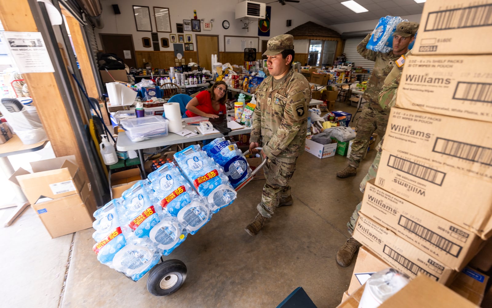 Soldiers with the 101st Airborne Division Air Assault, 2nd Brigade Combat Team, from Fort Campbell, Ky., help volunteers distribute water, food, toiletries, and other aid to residents in Maggie Valley on Tuesday, Oct. 8, 2024. (Travis Long/The News & Observer via AP)