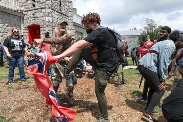 8/15/20 - Stone Mountain, GA - Protestors from both sides fight over a Confederate flag as several far-right groups, including militias and white supremacists, rally Saturday in the town of Stone Mountain, and a broad coalition of leftist anti-racist groups organized a counter-demonstration there after local authorities closed Stone Mountain park.   Alyssa Pointer / alyssa.pointer@ajc.com