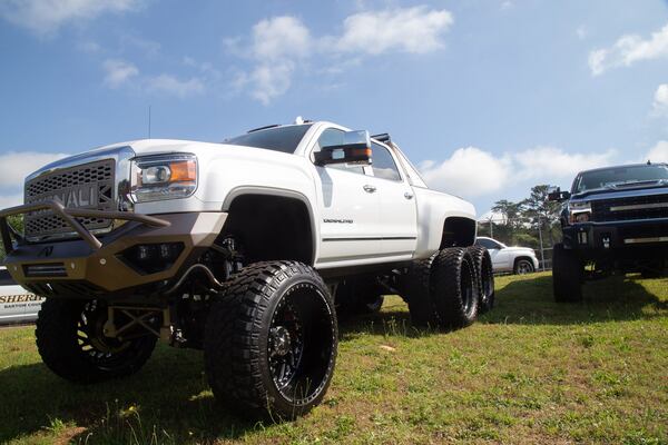 A highly modified GMC Sierra Denali along with many other expensive cars and trucks are on display before the start of a news conference about the recent arrest of construction company owner Juan Antonio Perez, in Cartersville Wednesday, May 8, 2019. In a recent raid, agents seized documents, high-priced vehicles, and other property from Perez’ homes and businesses in Cartersville, Rossville and in Hixson, Tennessee. STEVE SCHAEFER / SPECIAL TO THE AJC