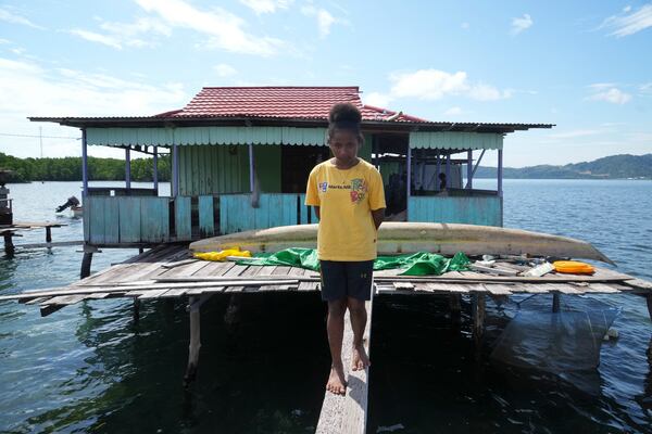 Martha Tjoe walks near her floating wooden house at Enggros village in Jayapura, Papua province, Indonesia on Wednesday, Oct. 2, 2024. (AP Photo/Firdia Lisnawati)